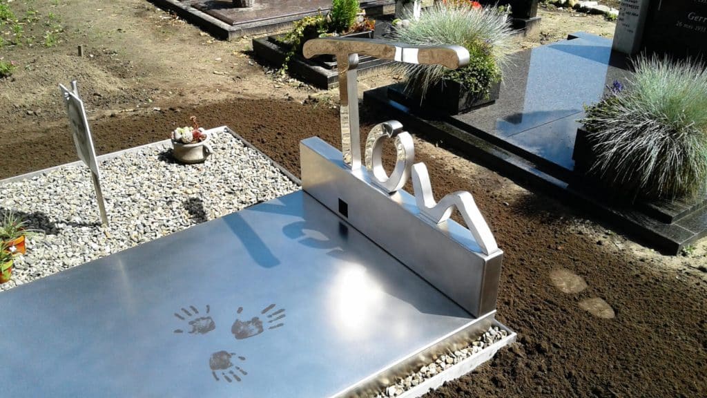 Modern grafmonument van spiegelend RVS met handafdrukken voor partner echtgenoot