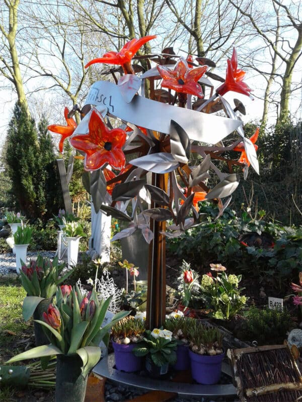 Modern en artistiek RVS en geroest grafmonument met prachtige gekleurde glazen bloemen voor partner