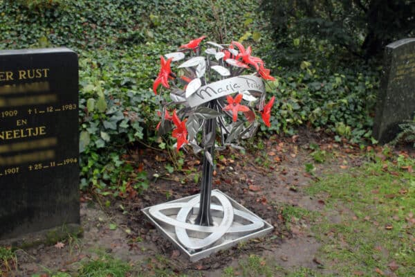 Modern en artistiek grafmonument met prachtige gekleurde glazen bloemen voor partner