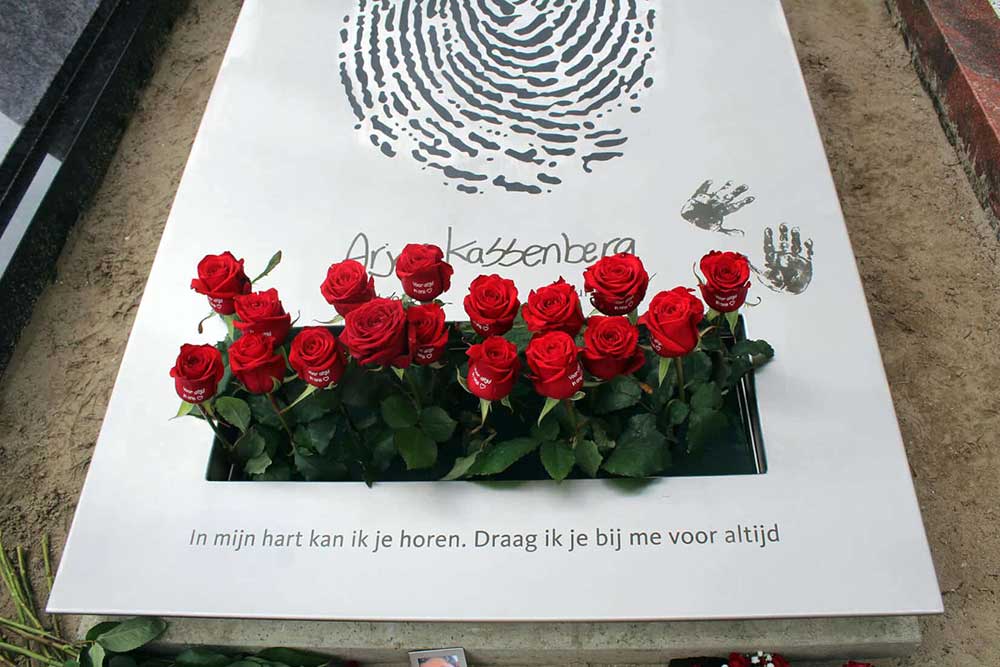 bloemen op eigentijds rvs grafmonument