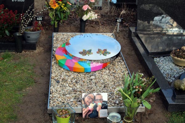 Modern RVS grafmonument met kleur en bladeren