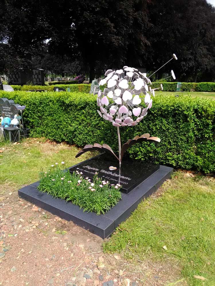 Een babygraf voor een meisje met roze glazen hartjes