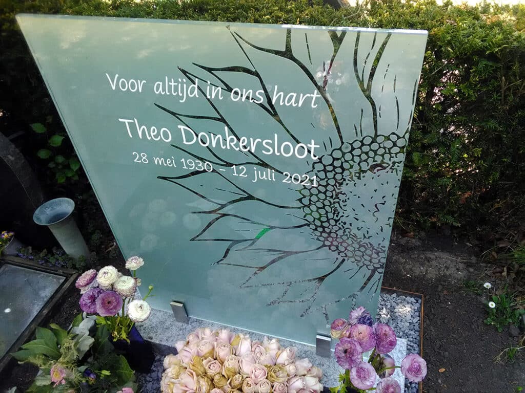 detail glazen grafsteen met zonnebloem