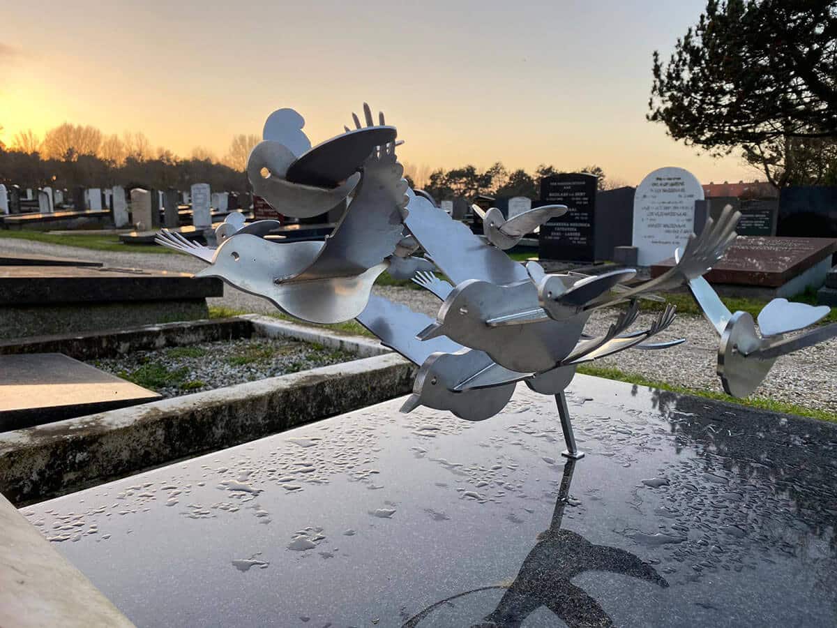 Bestaand traditioneel graf met moderne RVS vogels - grafkunst