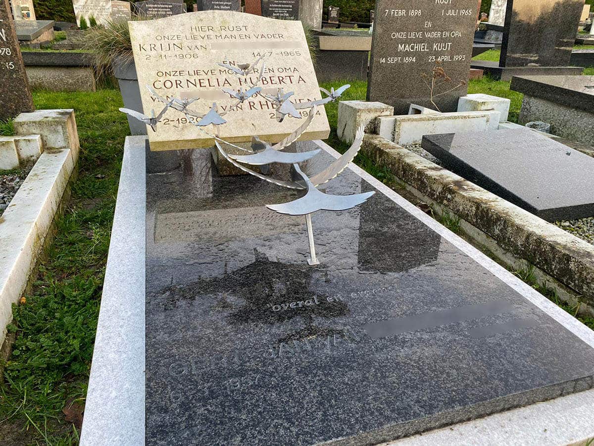 Traditionele grafsteen met grafkunst moderne RVS vogels