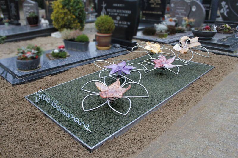 Modern RVS grafmonument met glazen bloemen voor jonge vrouw en naam in eigen handschrift