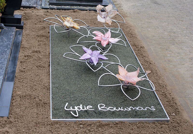 Eigentijds RVS grafmonument met glazen bloemen voor jonge vrouw