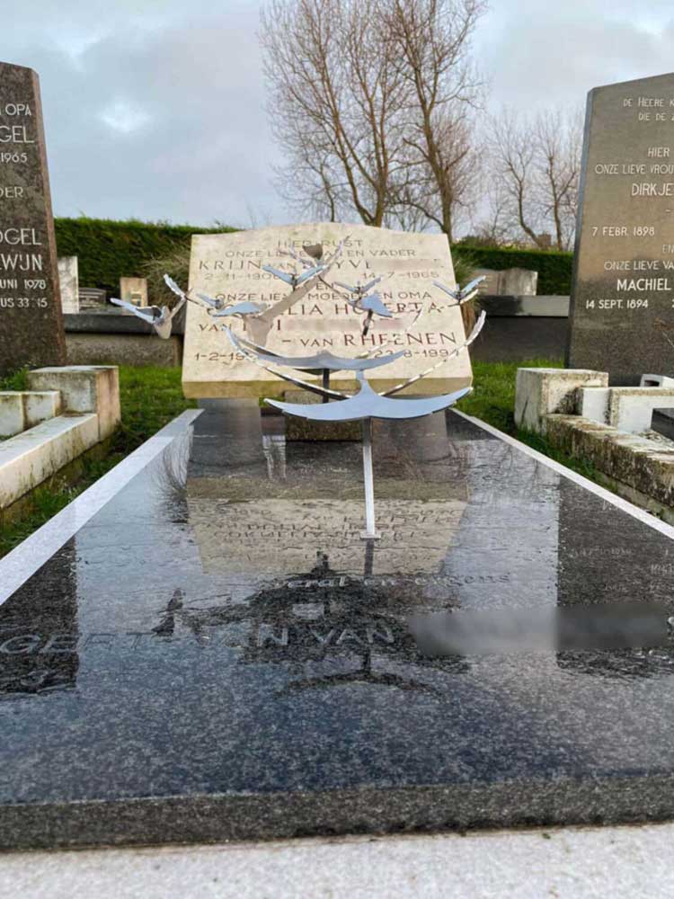 Reeds bestaand graf met grafkunst - moderne RVS vogels